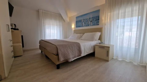 Camera da letto moderna e luminosa con letto matrimoniale.