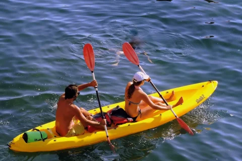 Due persone in kayak giallo sul mare.