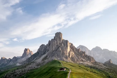 Montagne con rifugio su una collina verde