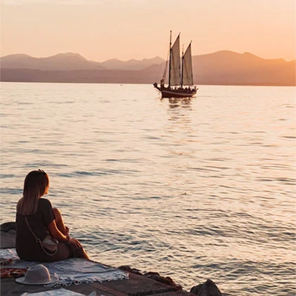 Tramonto sul lago con barca a vela.