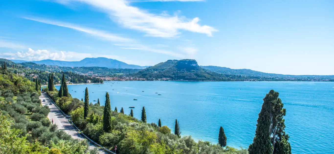 Scenic lake with cypress trees and hillside town