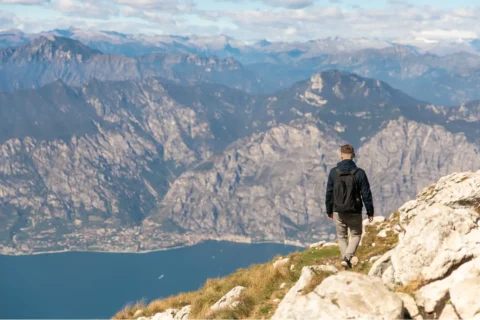 Persona cammina in montagna con vista sul lago