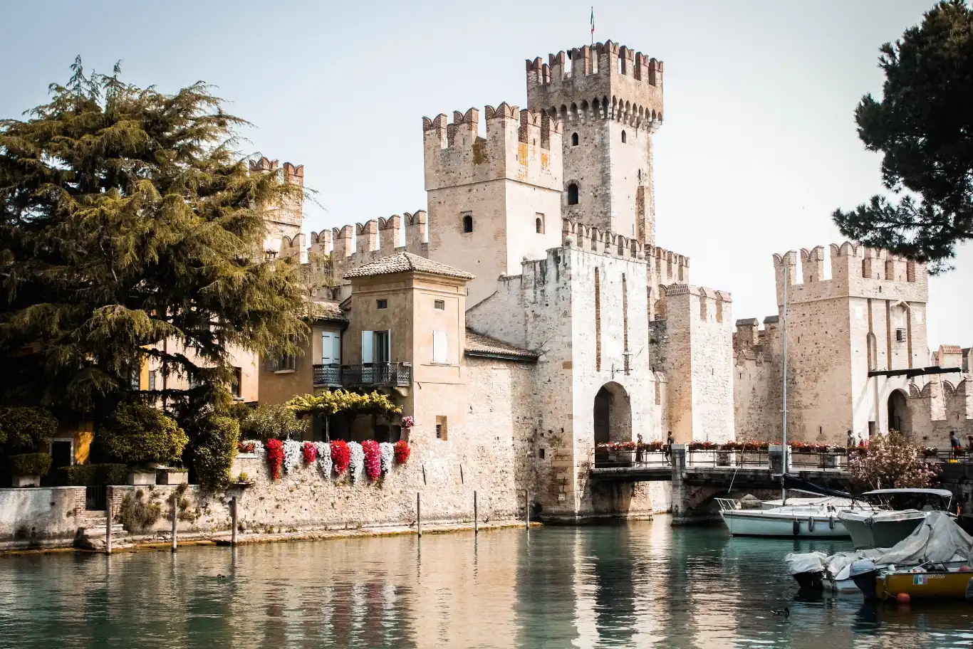 Castello medievale sul lago con barche.