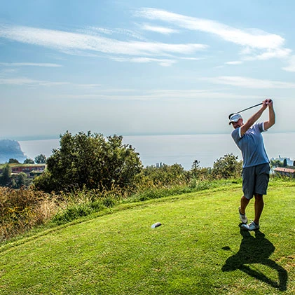 Giocatore di golf su prato verde vicino al mare.